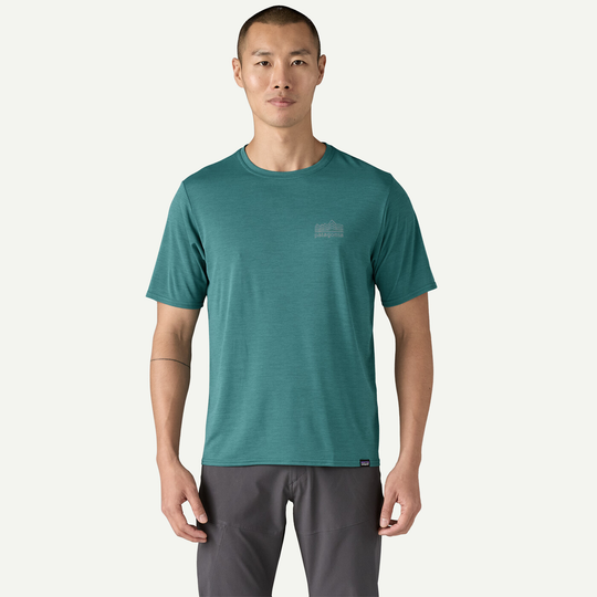 M's Cap Cool Daily Graphic Shirt featuring short sleeves, teal color, and lightweight design.