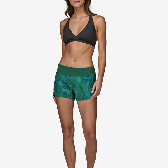 Stretch Hydropeak Surf Shorts modeled by woman; green pattern, black bikini top.