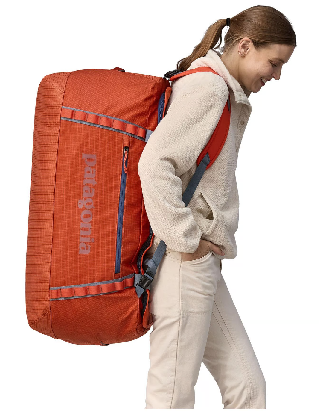 Black Hole Duffel 100L in use, showing removable shoulder straps and compact design.