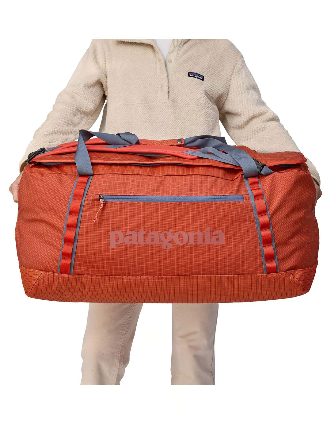 Black Hole Duffel 100L in recycled water-repellent fabric being held.