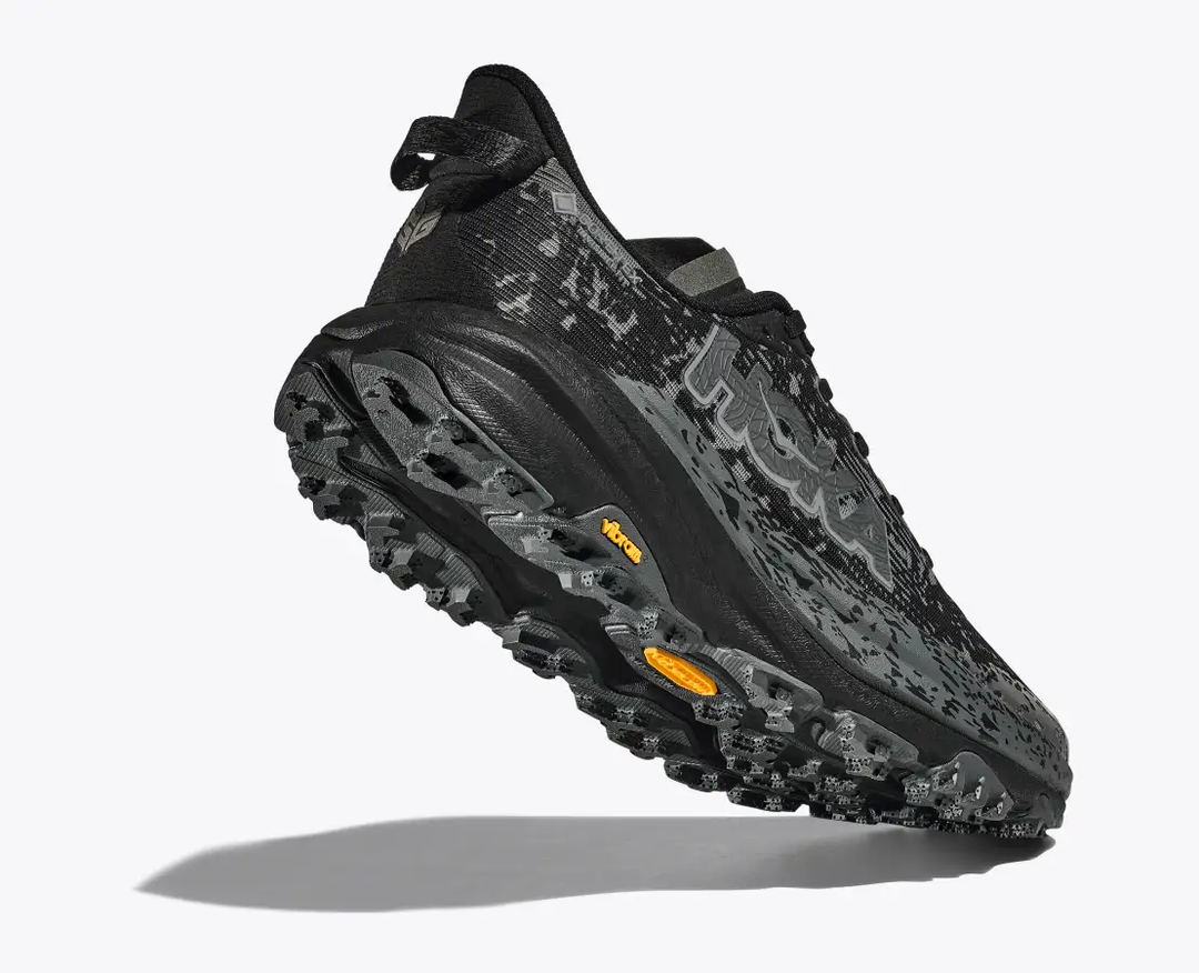 Speedgoat 6 Gtx trail shoe with black and grey design, featuring Vibram Megagrip outsole for enhanced traction.