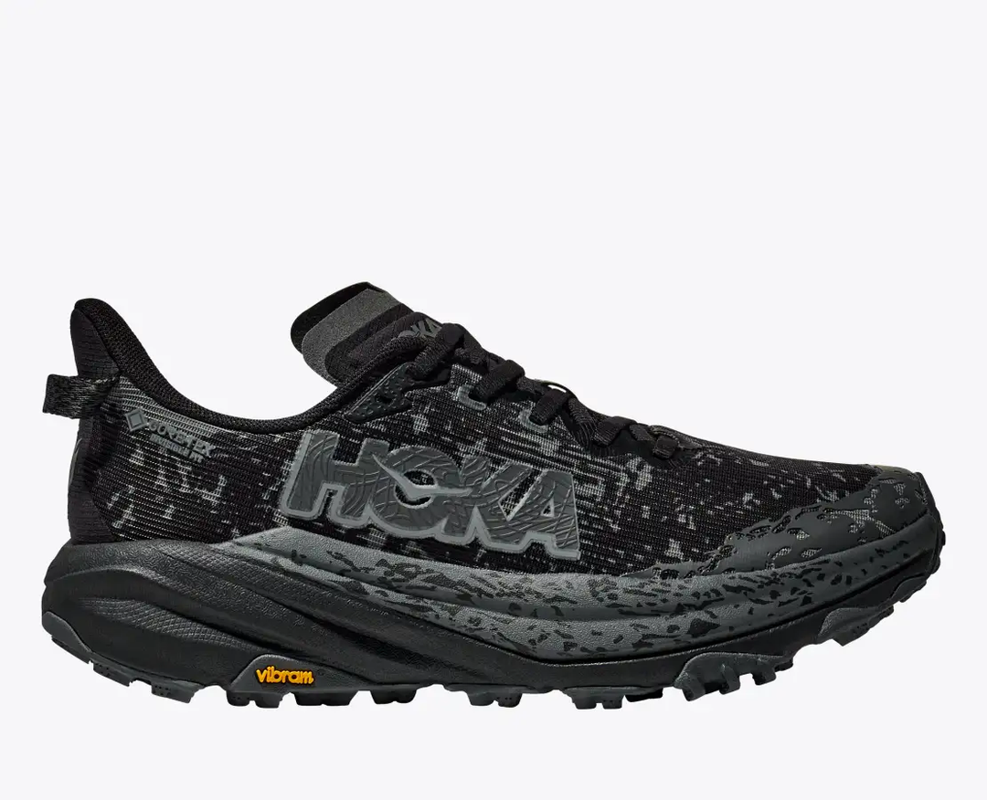 Trail running shoe Hoka W Speedgoat 6 GTX, black, featuring waterproof GORE-TEX, Vibram Megagrip sole, and flexible design.
