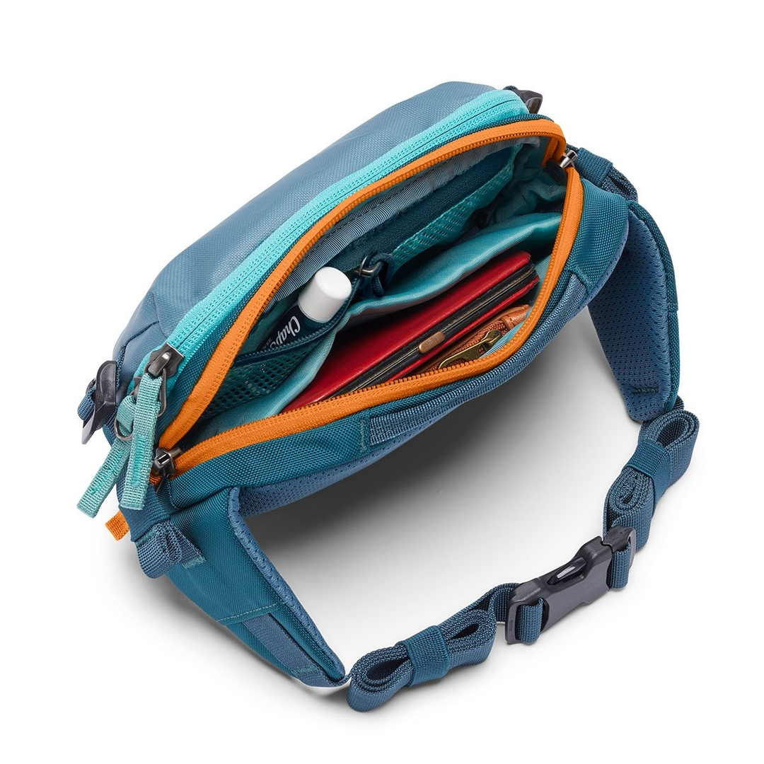 Allpa X 1.5L Hip Pack with dual-zippered main compartment open, showing inner pockets and adjustable waist strap.