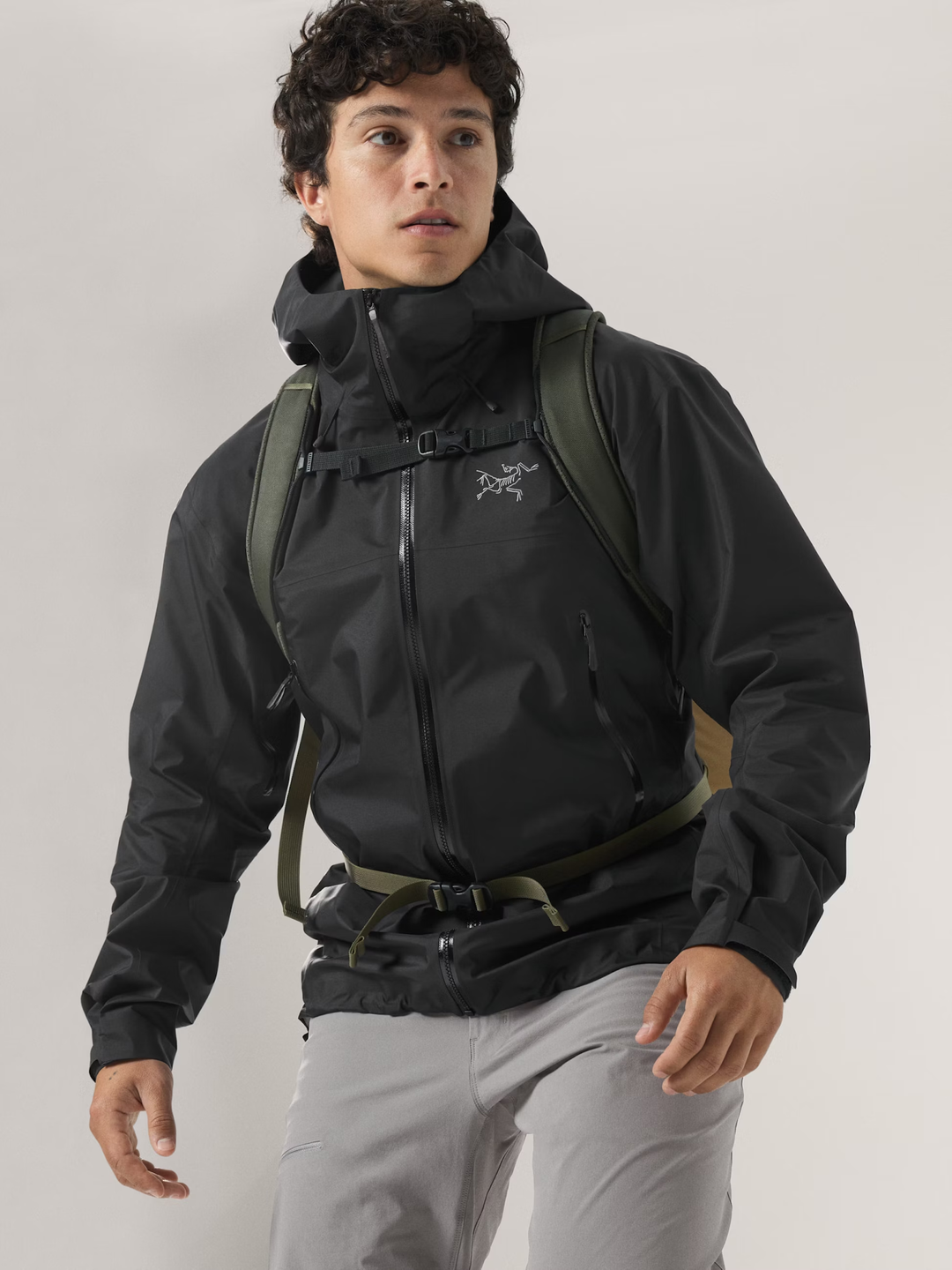 Beta SL Jacket M in nero, uomo in giacca impermeabile e traspirante, con cappuccio e cerniera, indossa zaino.