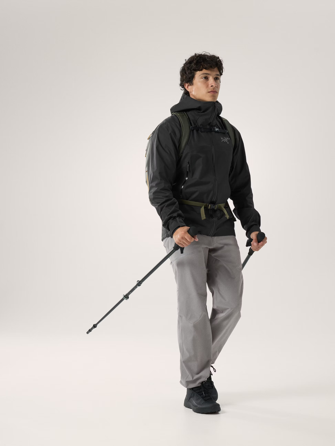 Beta SL Jacket M worn by a hiker with trekking poles, showcasing lightweight, waterproof, windproof, and breathable design.