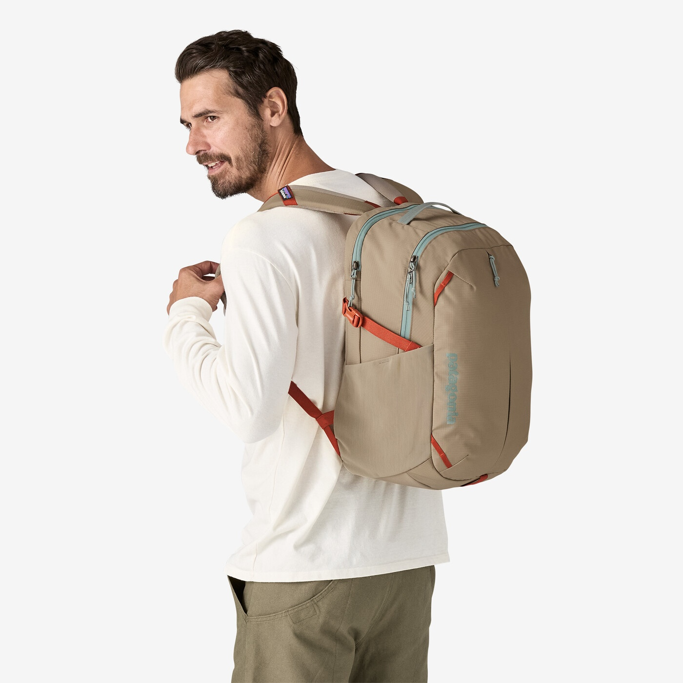 Refugio Day Pack 26L in beige worn by a person, showcasing its sleek design and adjustable straps.