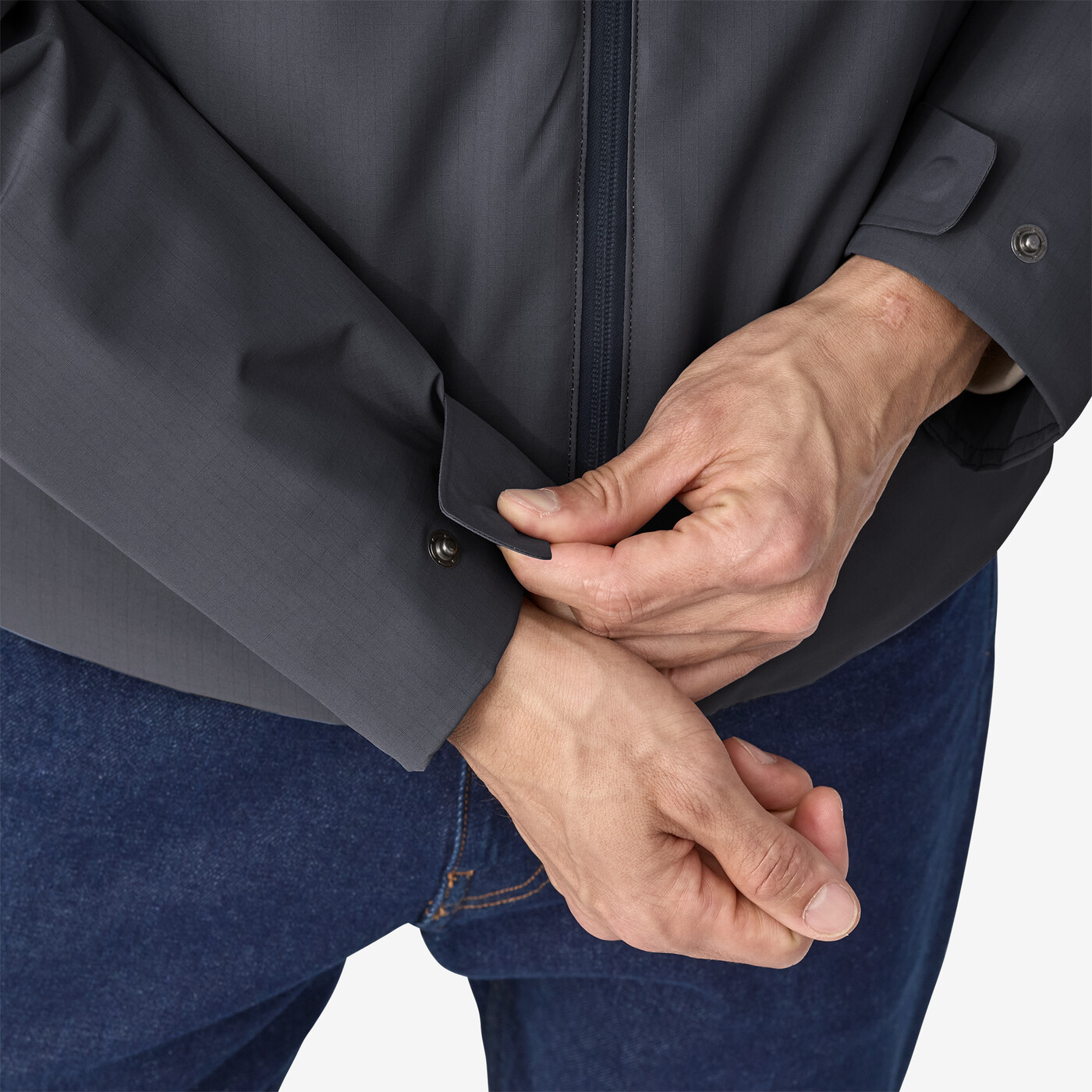 Windshadow Jkt sleeves being adjusted, showcasing buttoned cuffs and durable fabric.