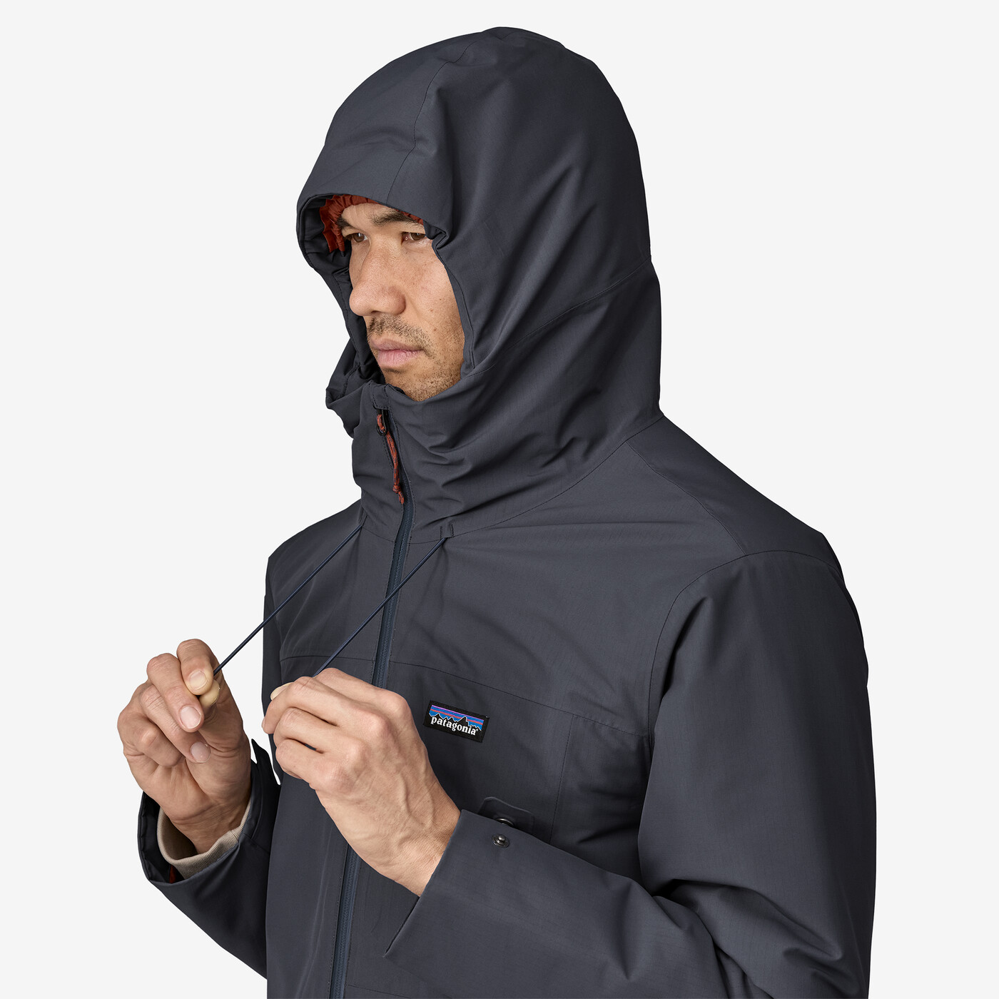 Windshadow Jkt in dark color, adjustable hood, and front zip, designed for harsh weather.