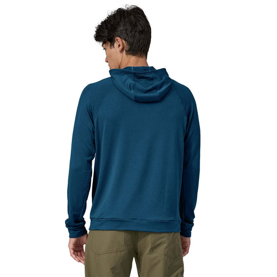 Man wearing blue Cap Thermal Hoody made from Polartec® Power Grid™ fabric with hood, showcasing breathable and odor-control technology.