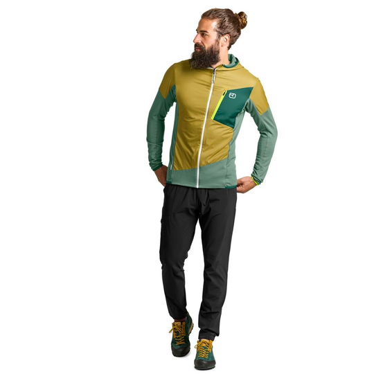 Man wearing Ladiz Hybrid Jacket, featuring Merino wool and windproof inserts, designed for alpine use.