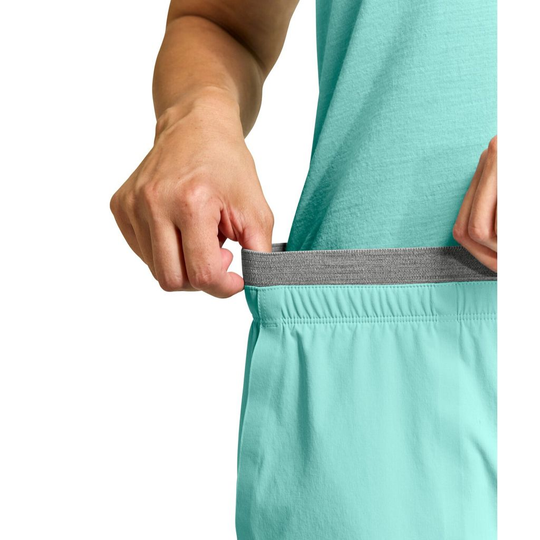Lightweight turquoise shorts with elastic waistband being stretched, showcasing comfort and fit.