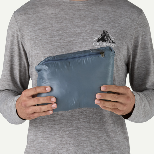 Nano Puff Hoody packed into its own pouch, held by a person in a gray shirt.