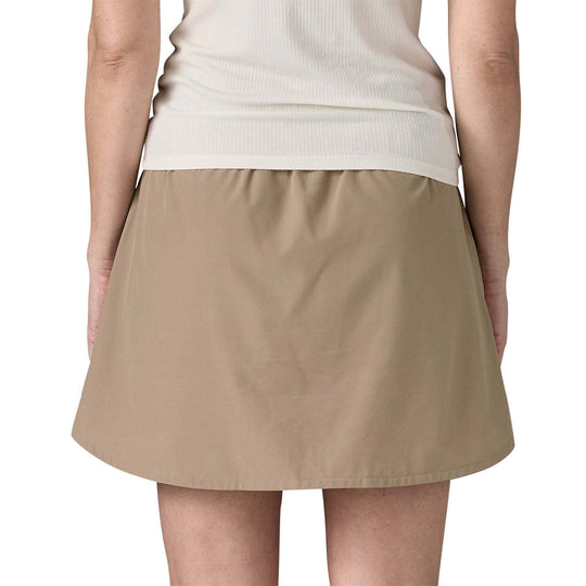 Women's Fleetwith Skort in beige, featuring a knee-length design, stretchy recycled polyester and elastane fabric, and elastic waistband with drawcord.