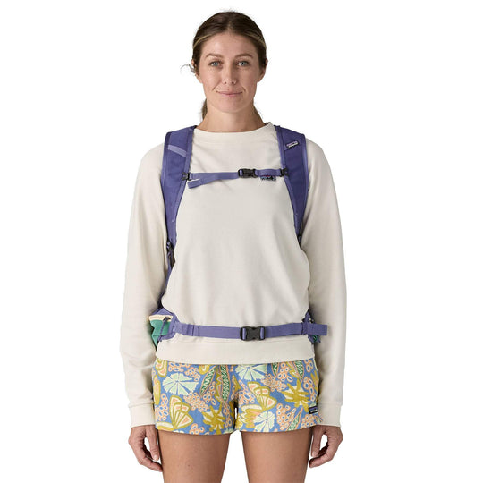 A person wearing a Terravia Pack 22L backpack in purple, showing front straps and waist belt.