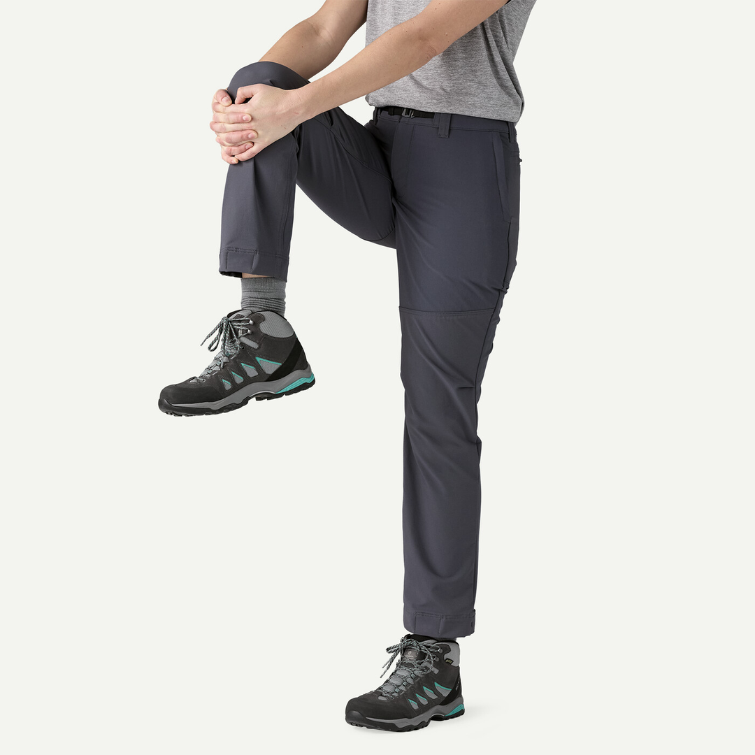 Versatile women's Terravia Peak Pants in dark color, featuring stretch fabric and adjustable integrated belt, perfect for adventures and compatible with boots.