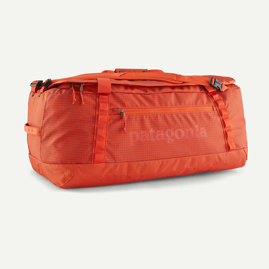 Black Hole Duffel 70L in arancione, borsa robusta idrorepellente con cinghie rimovibili.