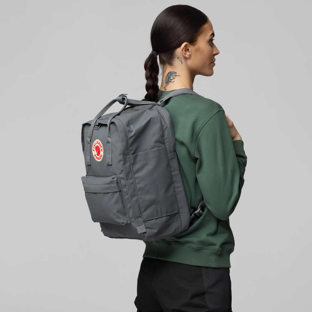 Kånken Laptop 15" backpack in grey, worn by a person, side view.
