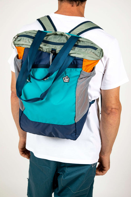 Person wearing a colorful bagpack showcasing pantaloni tecnici.