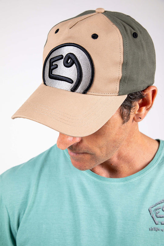 Cappello con visiera beige e verde con ricamo in rilievo, chiusura regolabile.
