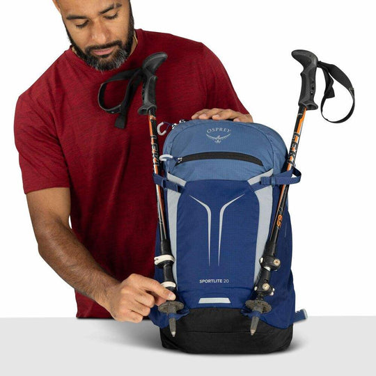 Zaino giornaliero blu in nylon riciclato, con dettagli neri, tasca frontale elasticizzata e attacchi per bastoncini da trekking.