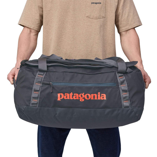 Black Hole Duffel 55L with robust, water-repellent recycled fabric, ergonomic straps, and versatile storage options.