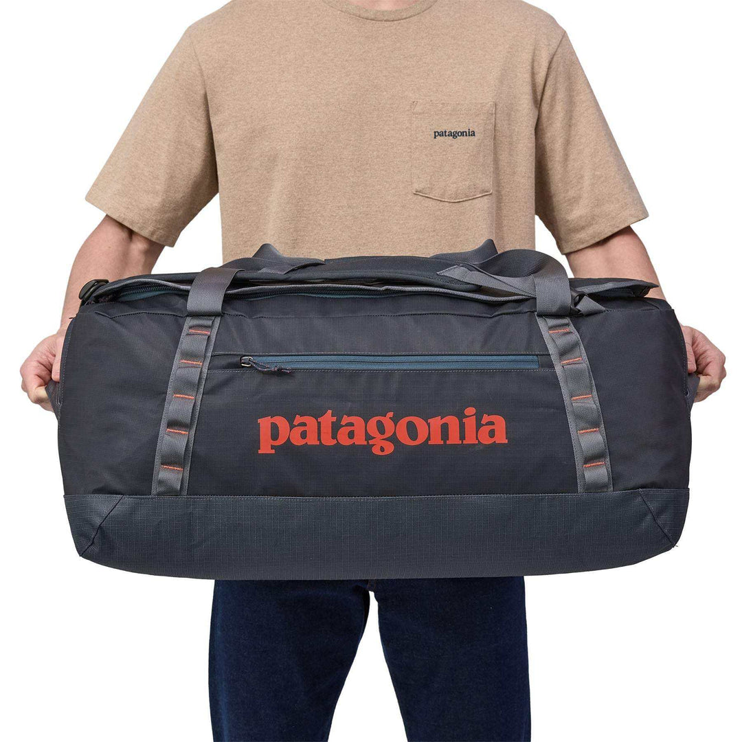 Black Hole Duffel 70L being carried, showcasing its large capacity and durable design by Patagonia.