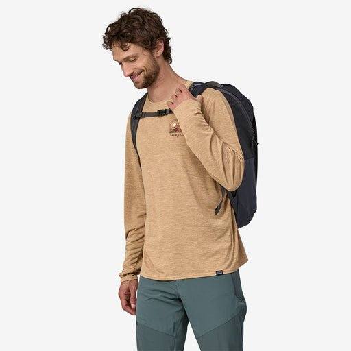 Black Hole Pack 25L backpack worn by a person, featuring recycled polyester fabric, water-repellent TPU film, and multiple organization options.