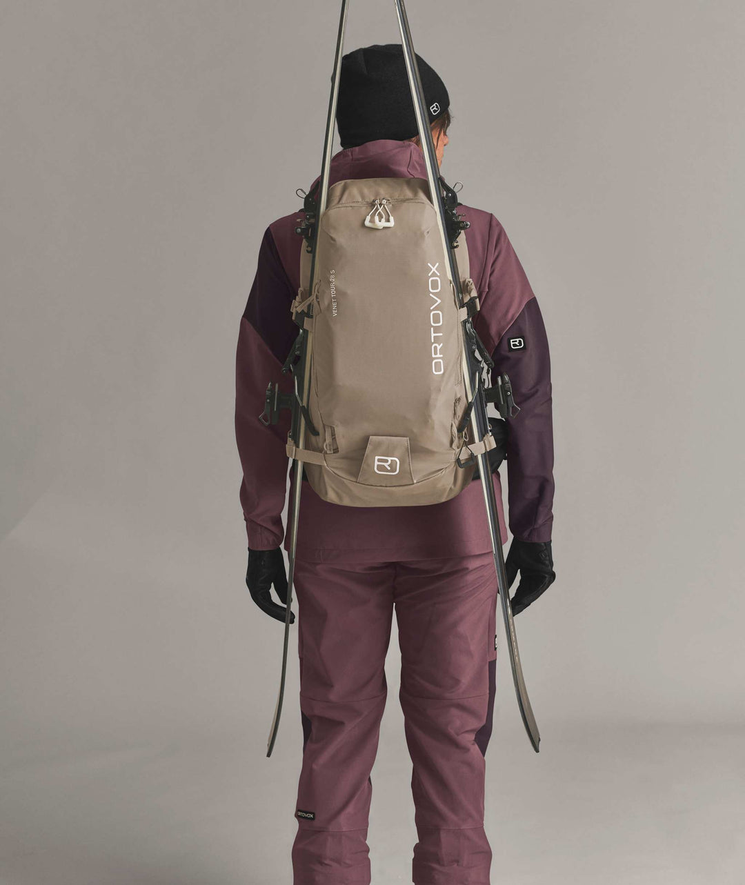 Ortovox Venet Tour 28 S Dark Linen, indossato con sci fissati lateralmente