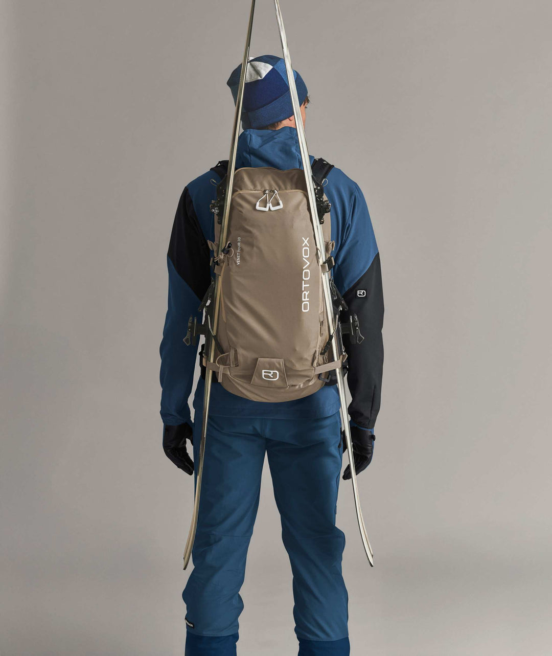 Ortovox Venet Tour 30 Dark Linen, indossato con sci fissati lateralmente