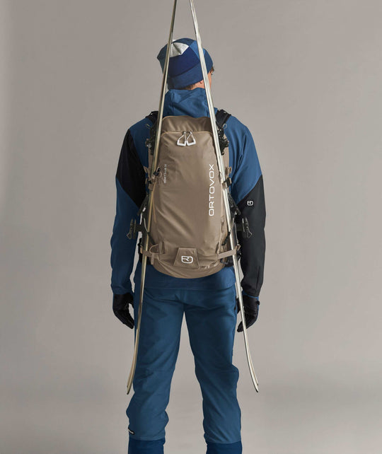 Ortovox Venet Tour 30 Dark Linen, indossato con sci fissati lateralmente