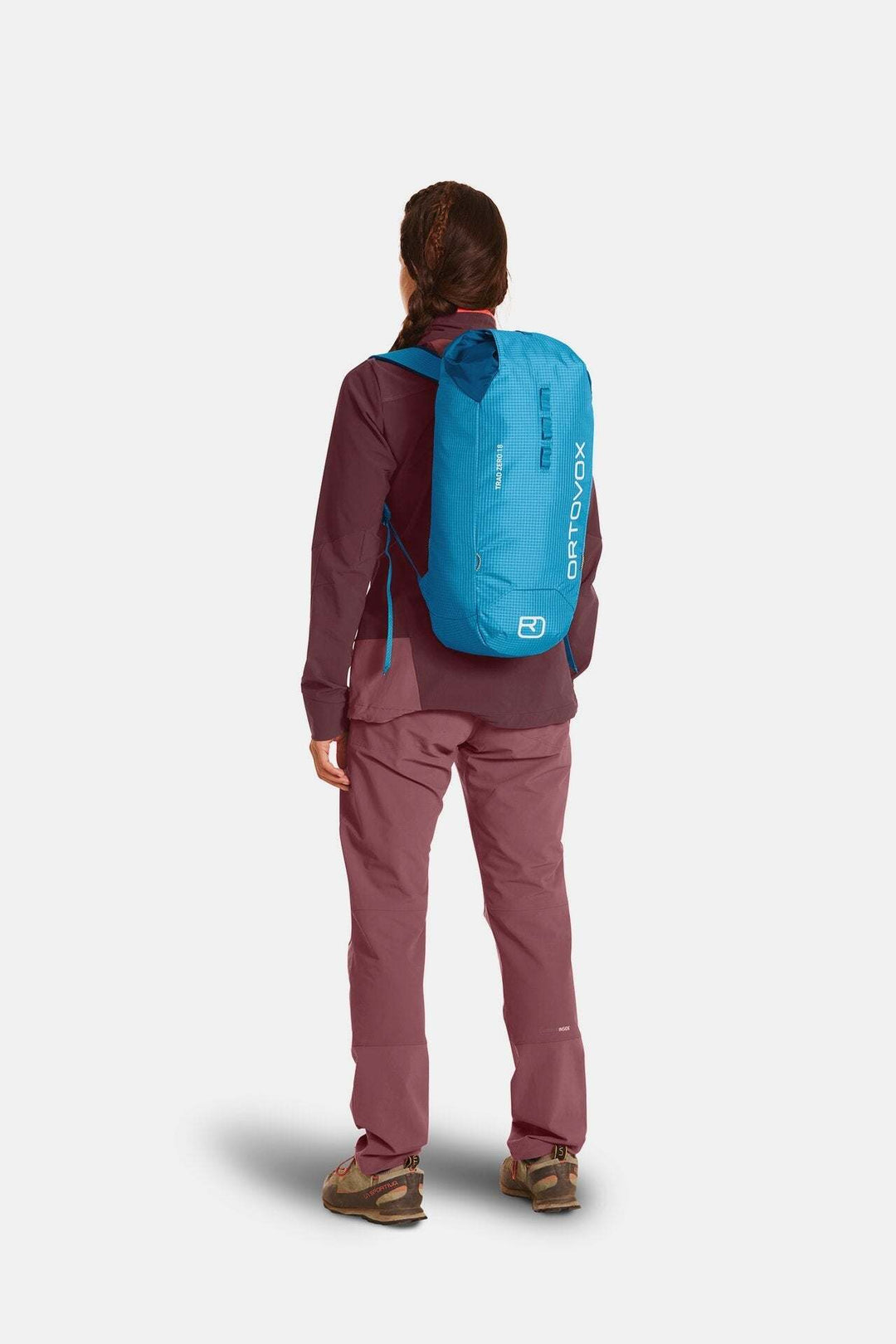 Lightweight Trad Zero 18 Alpine Climbing Backpack in blue, worn by a hiker.