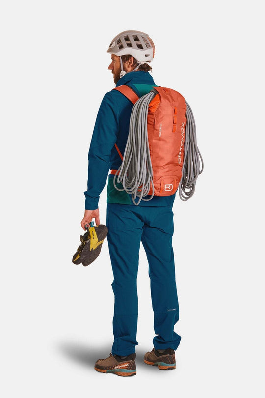 Lightweight orange Trad Zero 24 backpack for alpine climbing with attached rope and climbing helmet.
